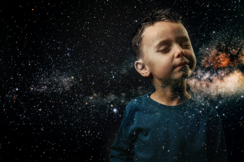 sweet child with eyes closed in backdrop of cosmos